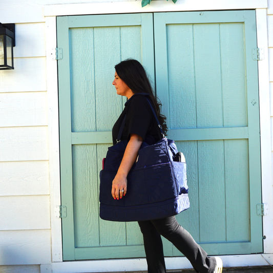 Sewist carrying a portable Cover & Carry sewing machine travel bag