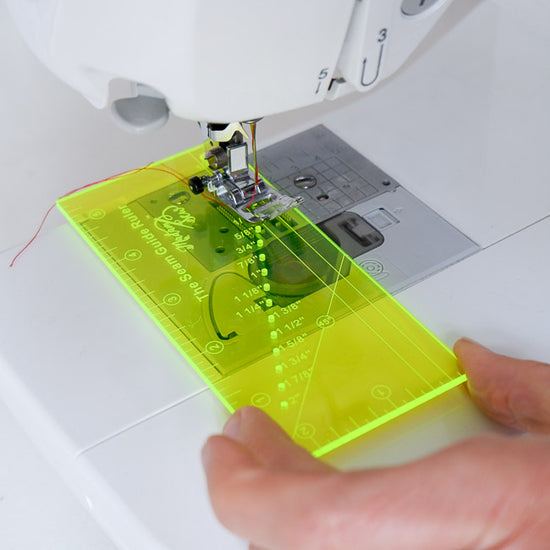 Sewing machine with a seam guide ruler on a white background