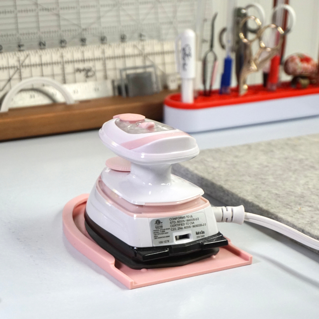 Madam Sew Mini Iron Rest with the Mini Iron sitting on it all on a work surface.