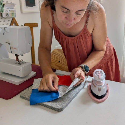 A women looking at seams while a mini iron rests on a pink mini iron rest.