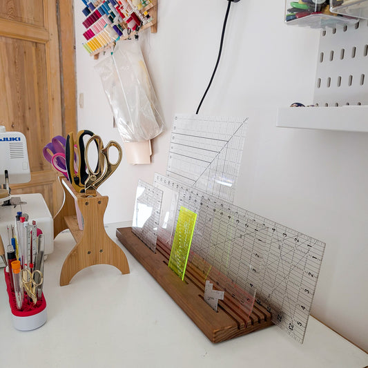 Quilting Ruler Holder filled with rulers on the side of a sewing table.