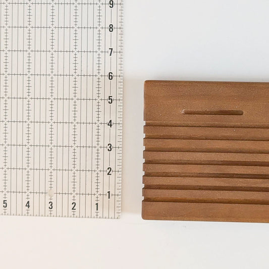 A quilting ruler showing the width of the Madam Sew Quilting Ruler Holder.