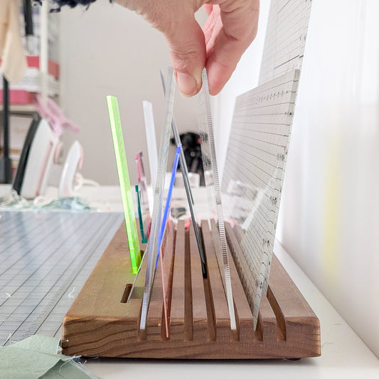 Someone reaching for a ruler in the Madam Sew Quilting Ruler Holder.
