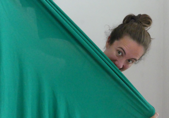 Women holding a green piece of fabric