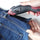 Cutting blue jeans trousers with Electric Fabric Scissors