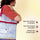 Women holding a project bag with tools and materials for punch needling