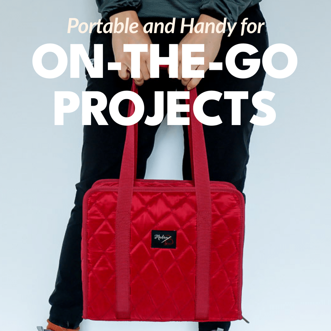 woman holding the red binder bag out in front of her by its long straps