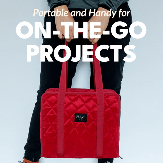 Woman holding the binder bag by Madam Sew in front of her with the long handles