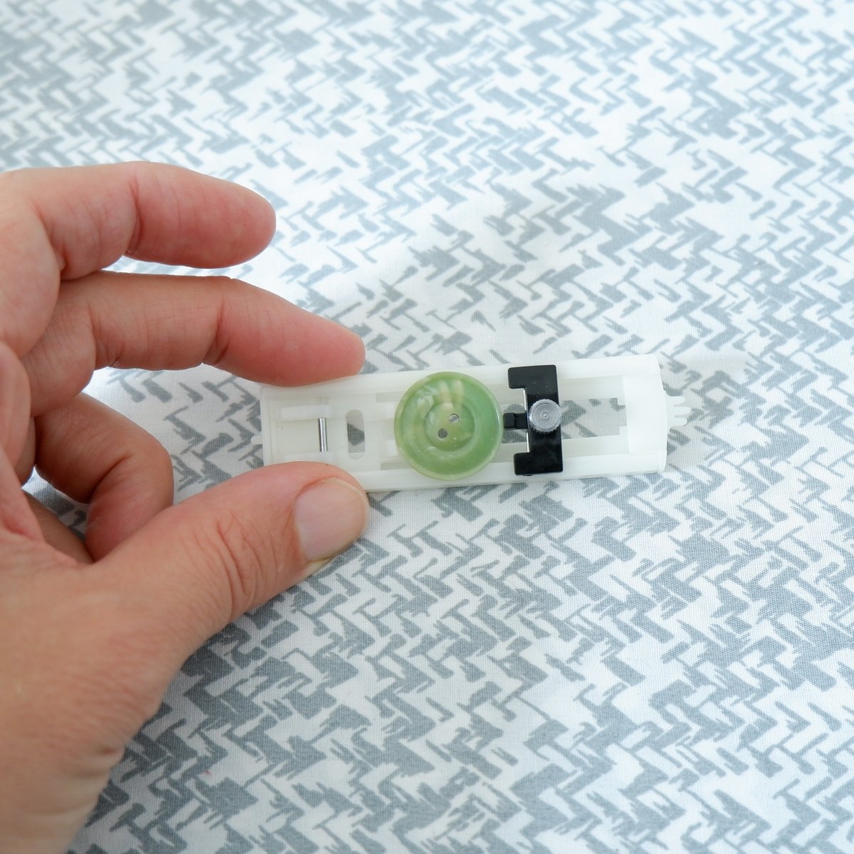 A button sitting on the Buttonhole Presser Foot.