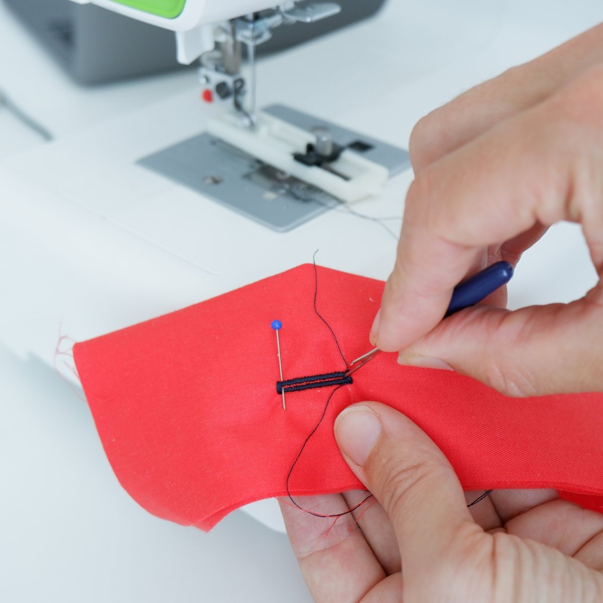 Cutting a buttonhole open using a seam ripper.