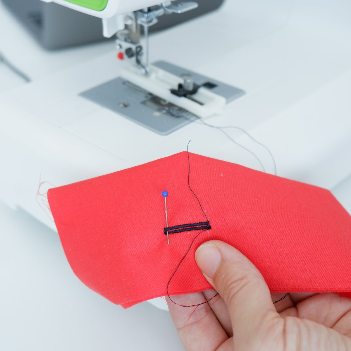 Putting a pin at the end of a buttonhole prior to cutting the hole open.