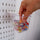 a transparent box on a peg board with sewing clips