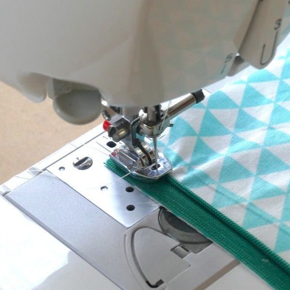 The Invisible Zipper Foot being used to sew an invisible zipper to fabric on the left.