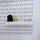 White long plastic tray attached to a peg board holding thread spools and other sewing notions