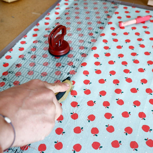 Quilting ruler with a ruler grip used to cut fabric with a rotary cutter