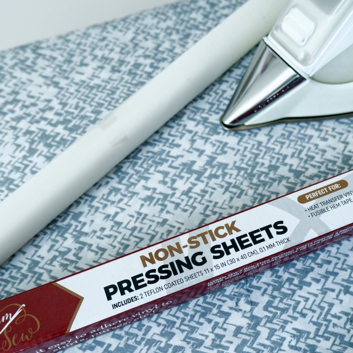 Non-Stick Pressing Sheet with the box and an iron