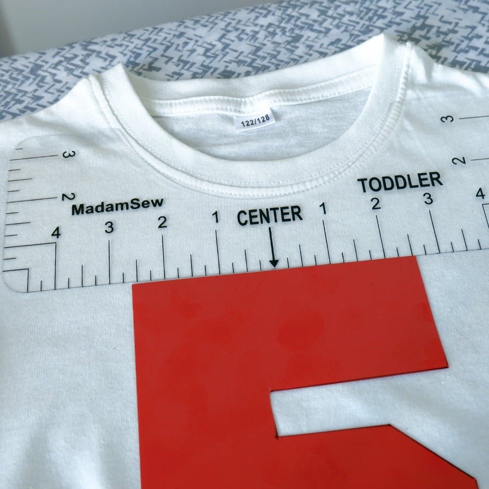 A t-shirt ruler on the collar of a white t-shirt to center the number accurately