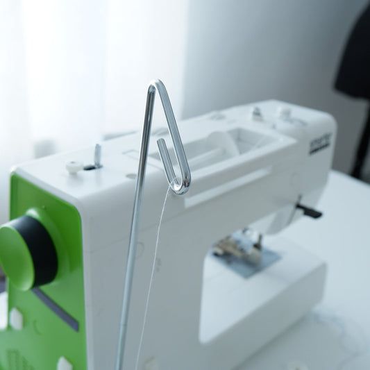 Sewing machine cone holder next to a sewing machine by Madam Sew