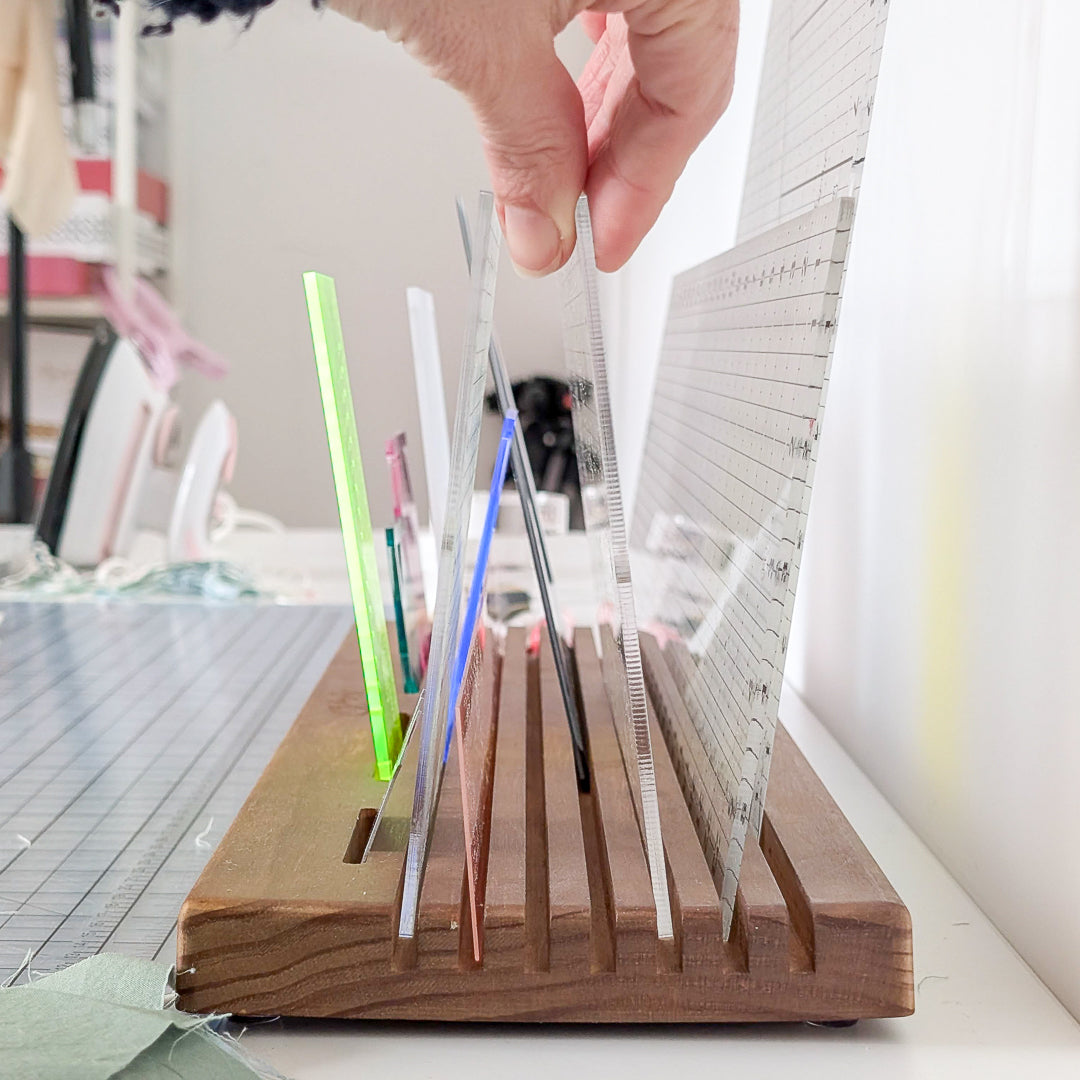 Someone reaching for a ruler in the Madam Sew Quilting Ruler Holder.