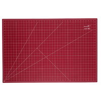 A red A1 cutting mat with white grid lines, measurement markings, and a small white Madam Sew logo in the top right corner, shown flat against a white background.