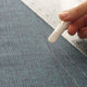 Detail of the chalk wheel of a white chalk marker with two thin lines drawn on fabric and a ruler