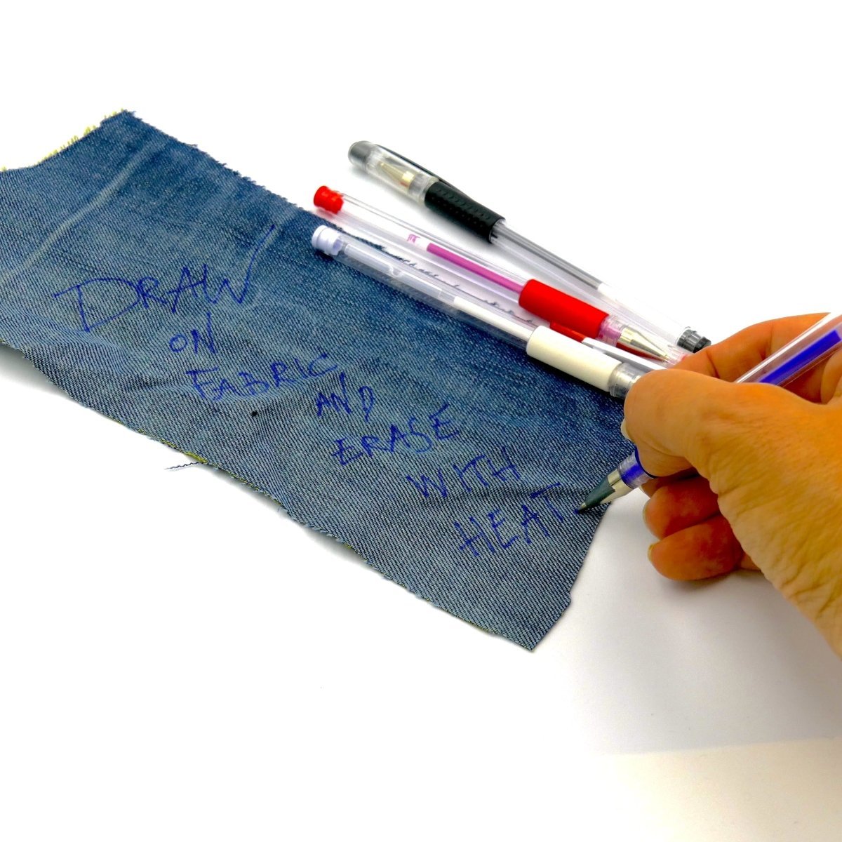 writing text on denim with a blue fabric marker that is erasable with heat