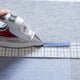 Someone uses a hot hem ruler  and iron to iron a hem on dotted fabric