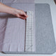 Someone using a Hot Hem Ruler for Sewing  pastel fabric on a wool pressing mat
