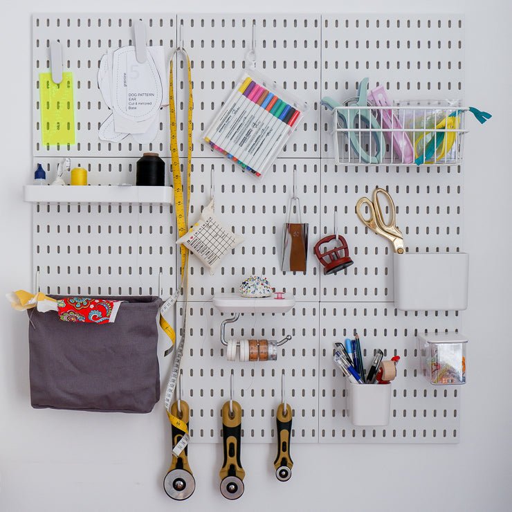 The Madam Sew peg board on the wall with all kinds of sewing tools and notions attached to it