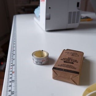 MadamSew Adhesive Ruler Tape on work surface, with extra roll and box.