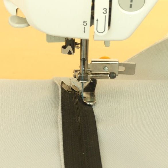 Adjustable zipper foot sewing a zipper with the needle in the notch