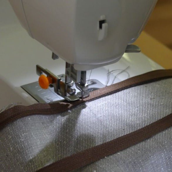 Adjustable zipper foot sewing next to zipper teeth without running into them.
