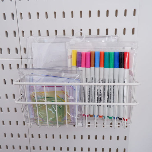 wired basket holding markers and acrylic templates for quilting on a peg board