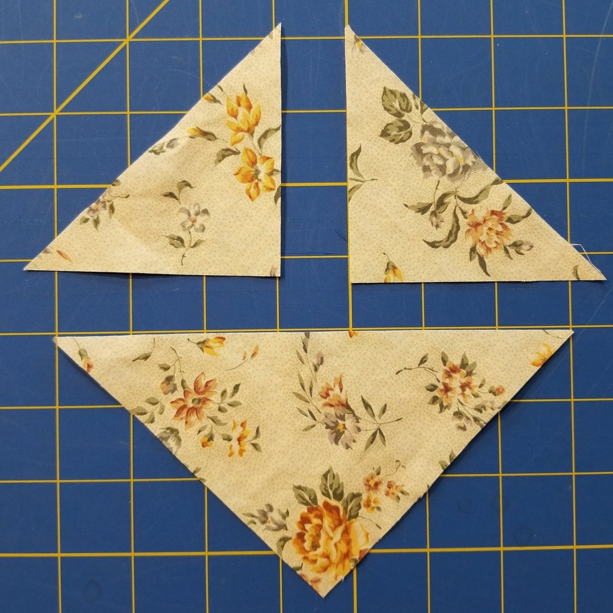Different sizes of triangles cut in fabric with the Creative Shape Cut Ruler