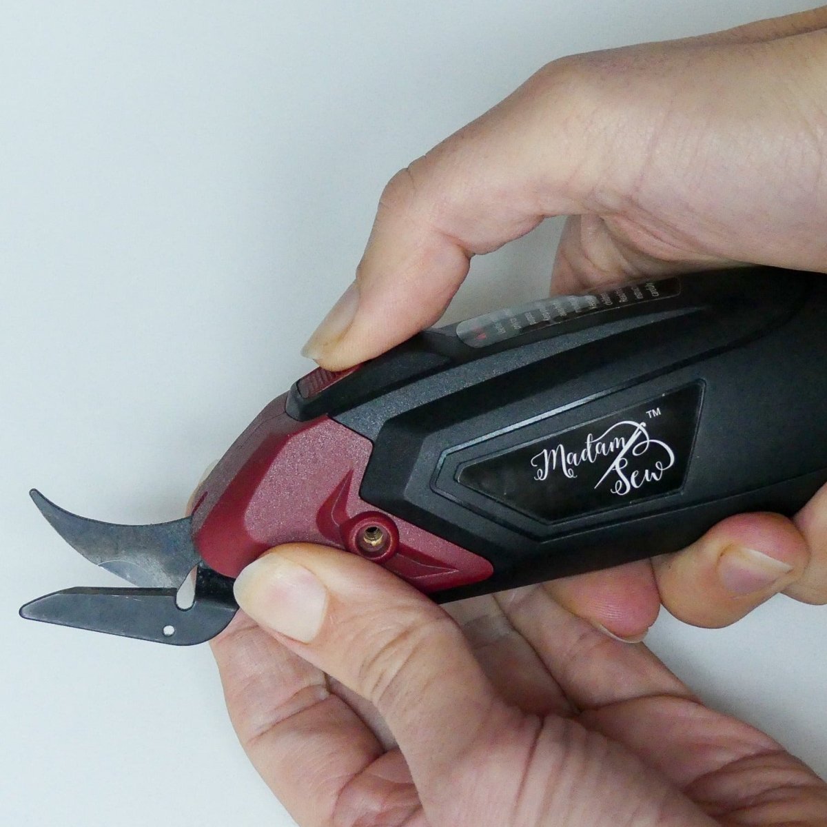 Pulling on the head of the electric fabric scissors to remove the head and replace