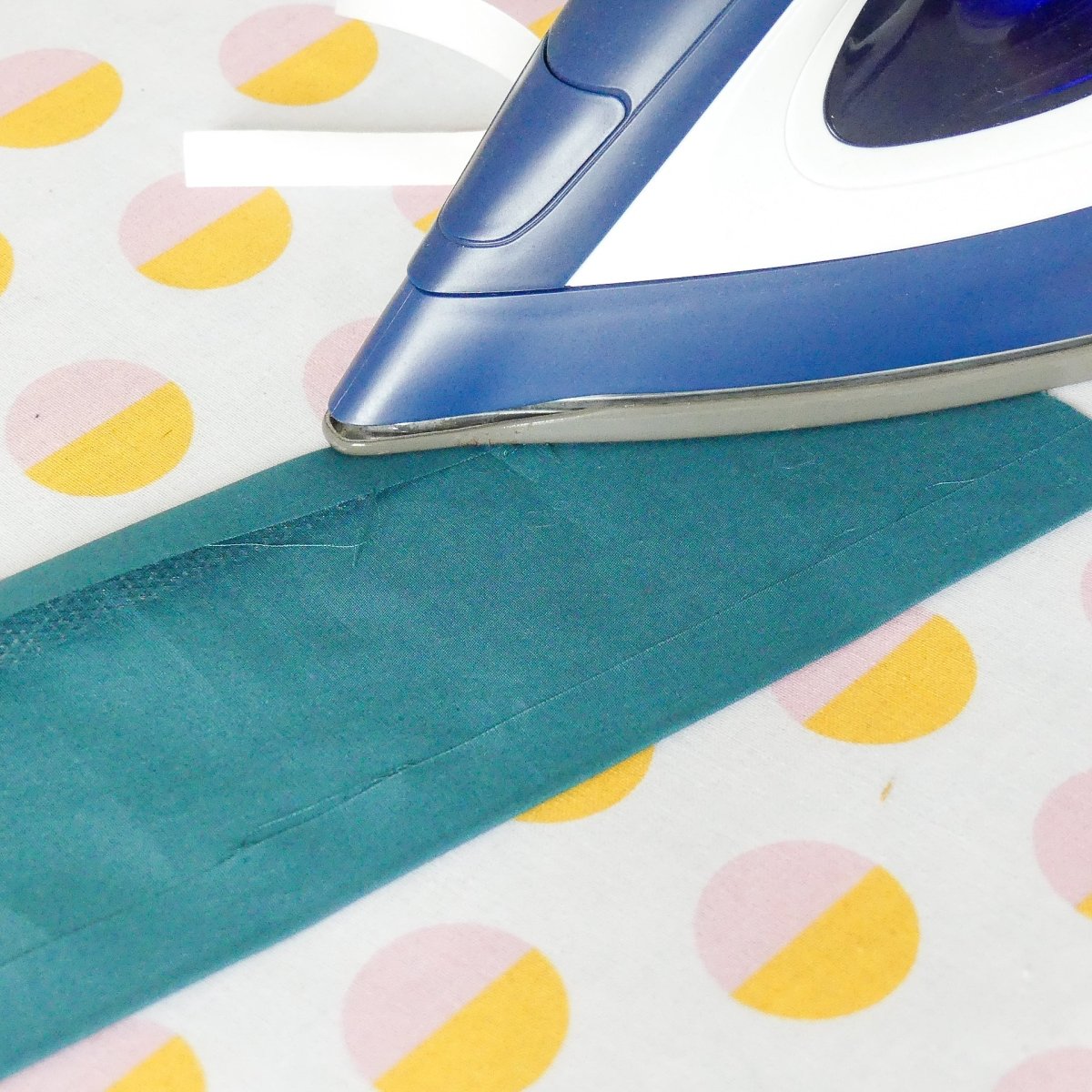 Ironing hem in place with fusible hem tape