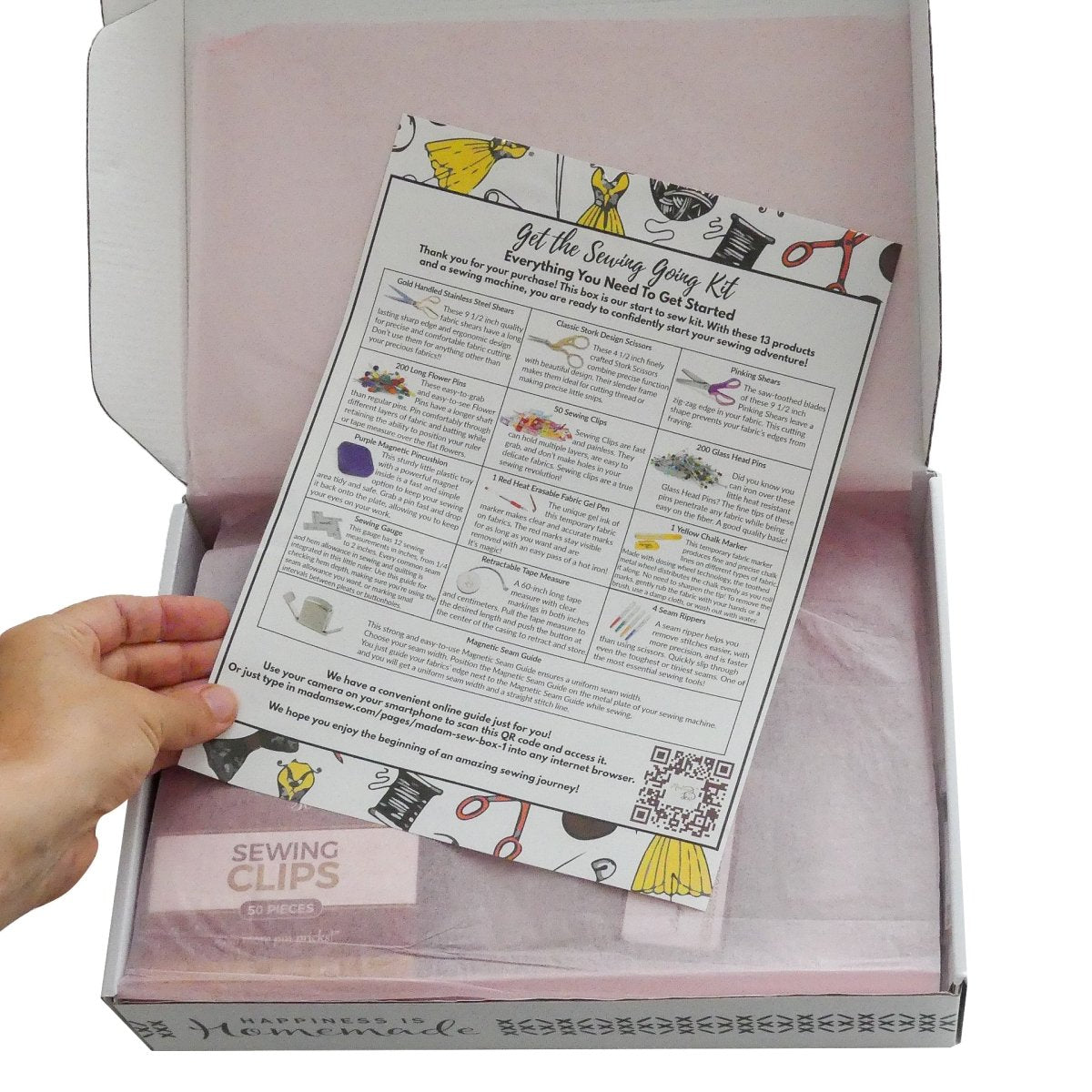A hand showing the instructions that are in the sewing basics kit