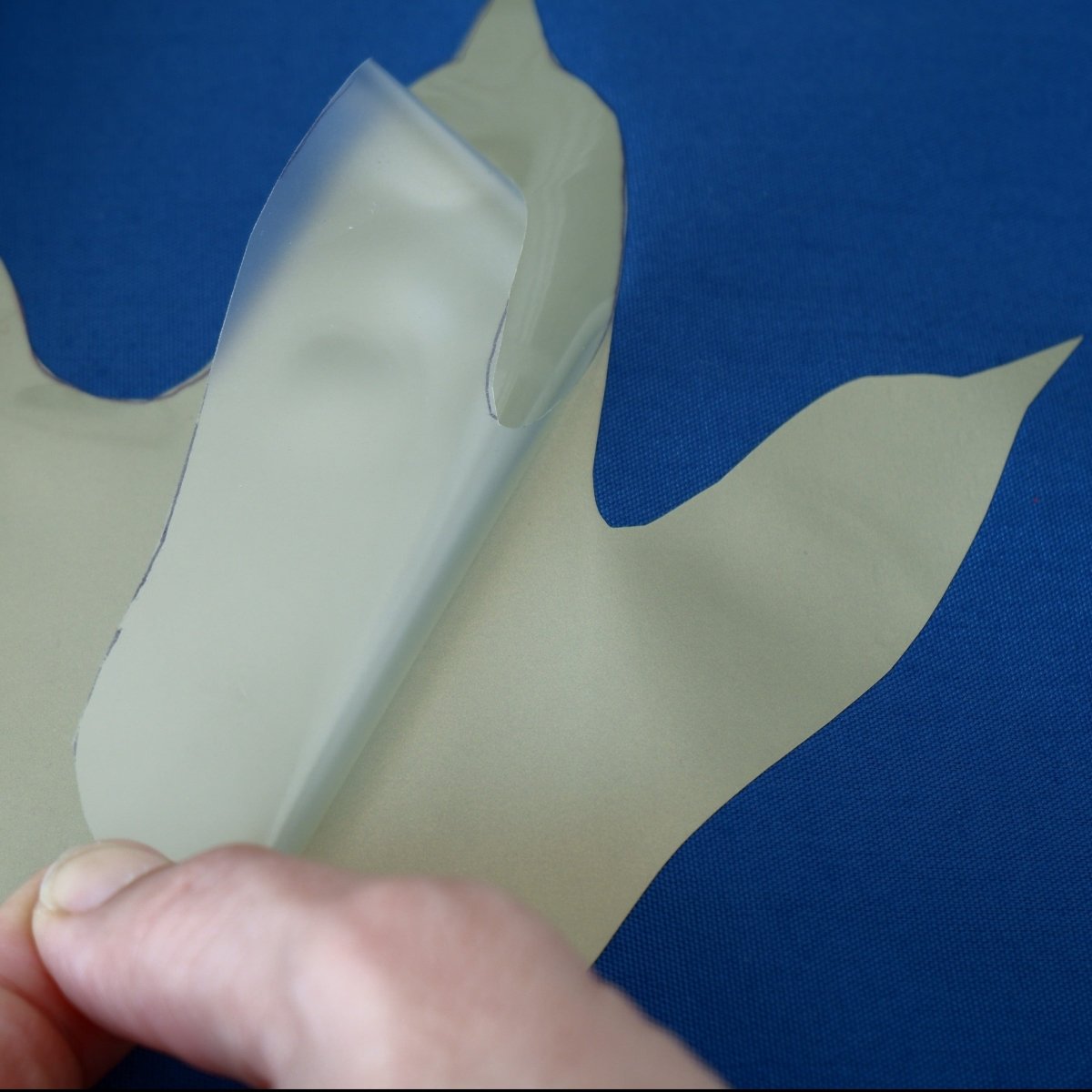Peeling protective layer off of a pressed on Heat Transfer Vinyl shape