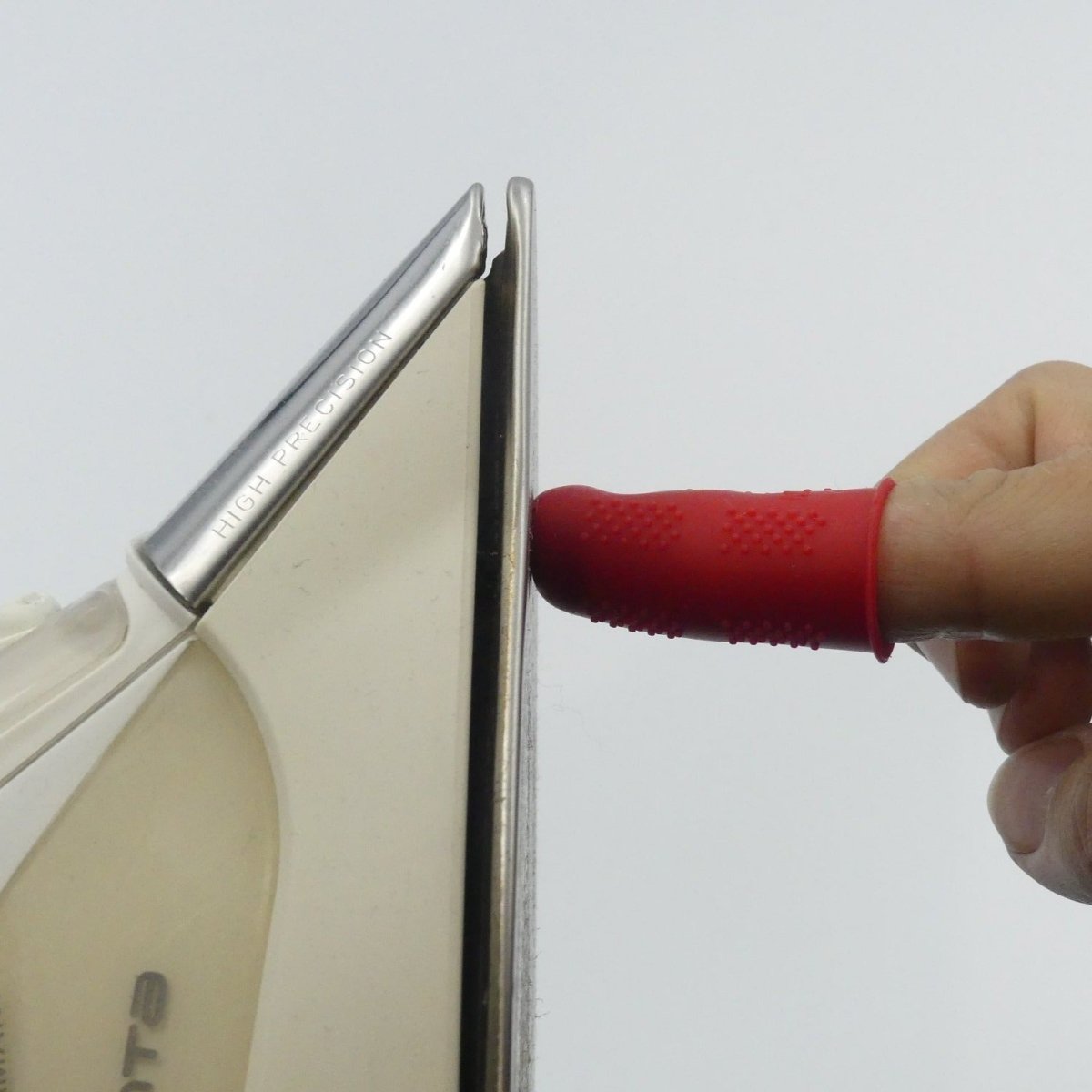 Touching the bottom plate of an iron with an Ironing Thimble encased finger
