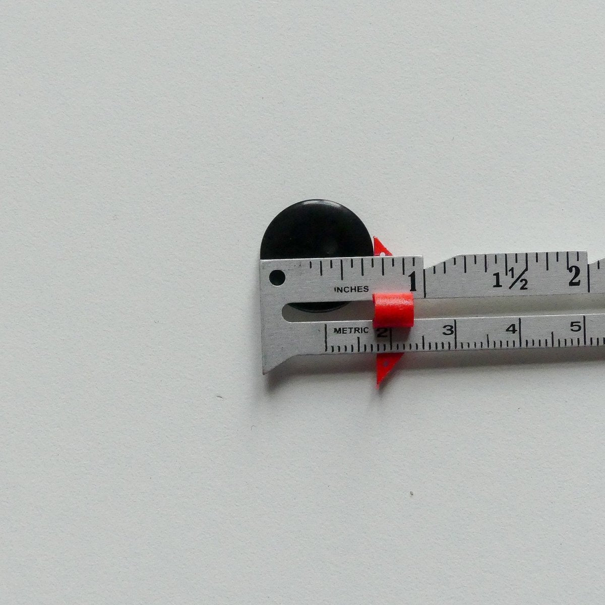 measuring a button with a measuring gauge with a slider