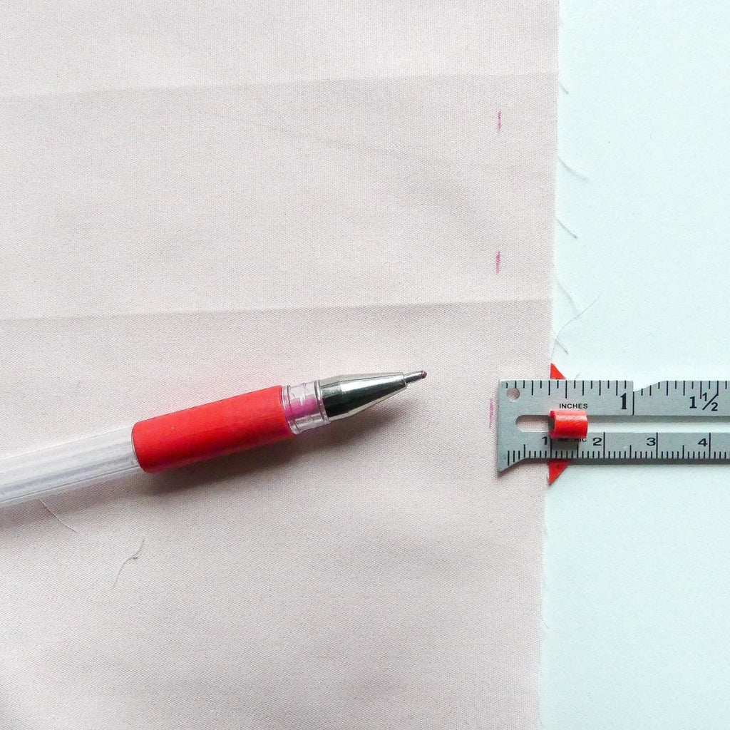 Marking hems on fabric with the measuring gauge and a marking pen