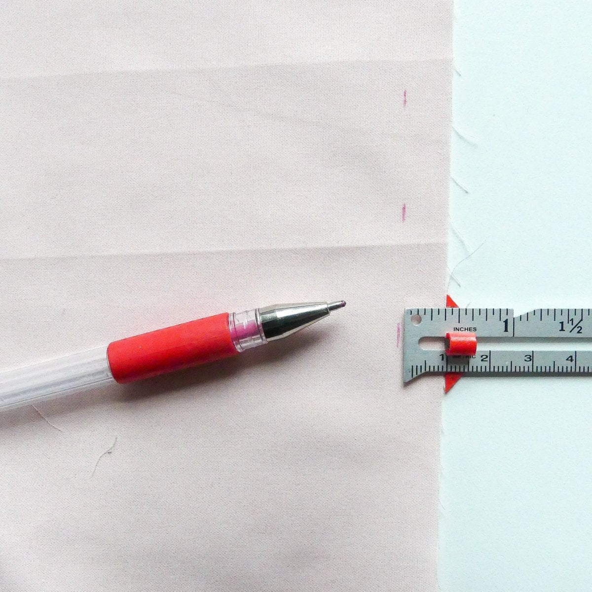 Marking hems on fabric with the measuring gauge and a marking pen