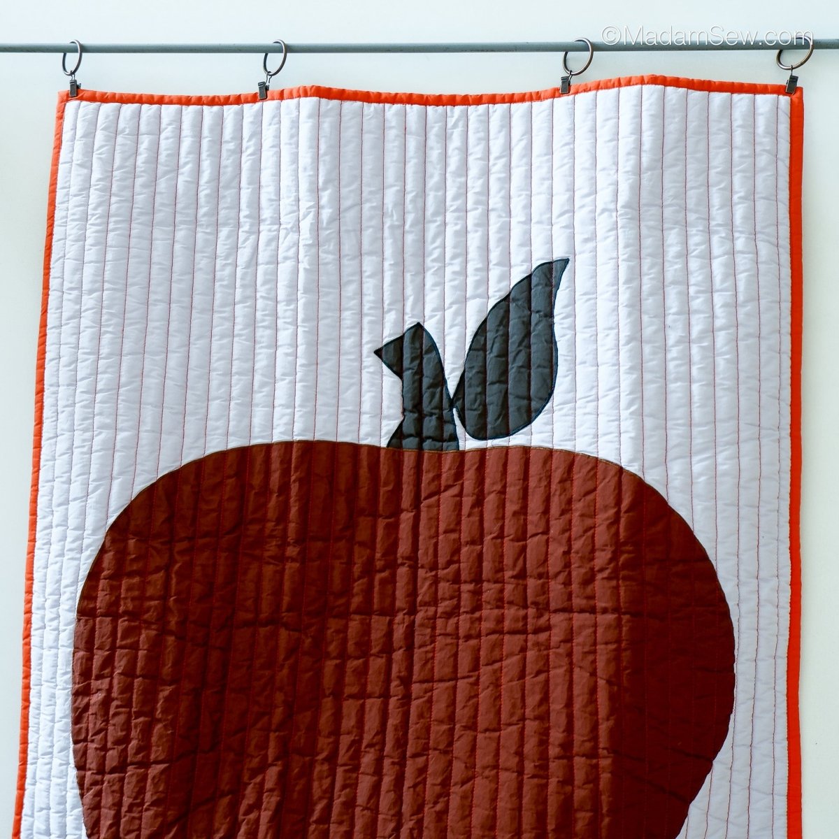Quilt hanging from a rod by using Metal Curtain & Quilt Hangers