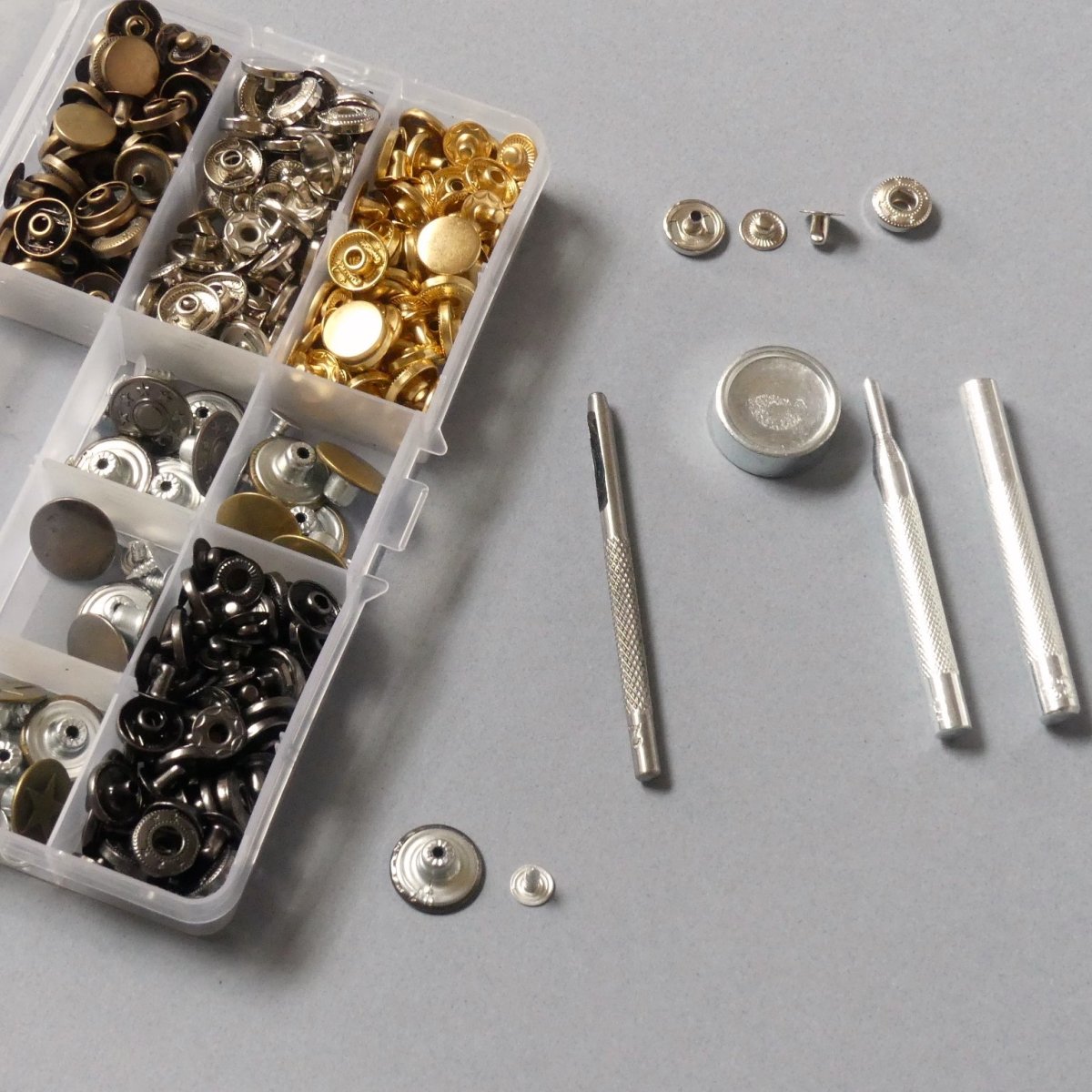 a metal snap button set with the tools to install the buttons on fabric or clothing