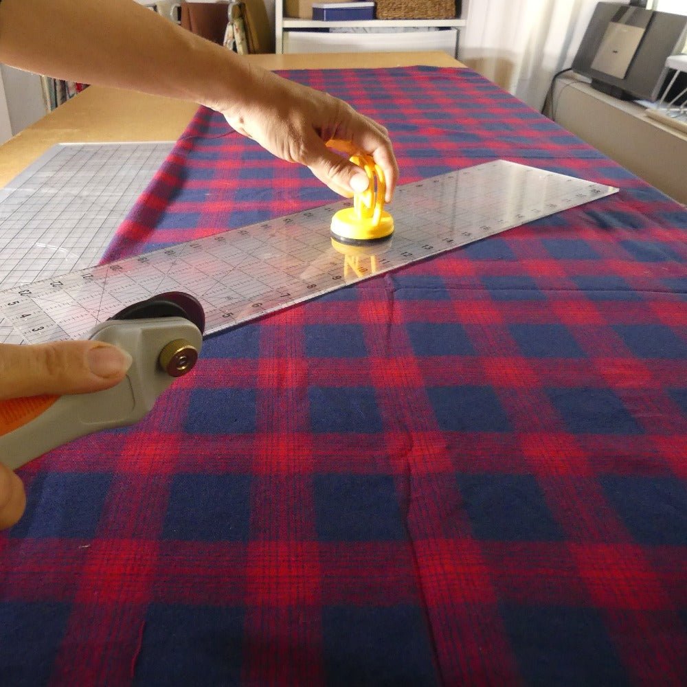 use a large quilting ruler to cut a large piece of fabric with a rotary cutter