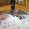 the overcast foot on a sewing machine finishing the seam of 2 joint fabrics