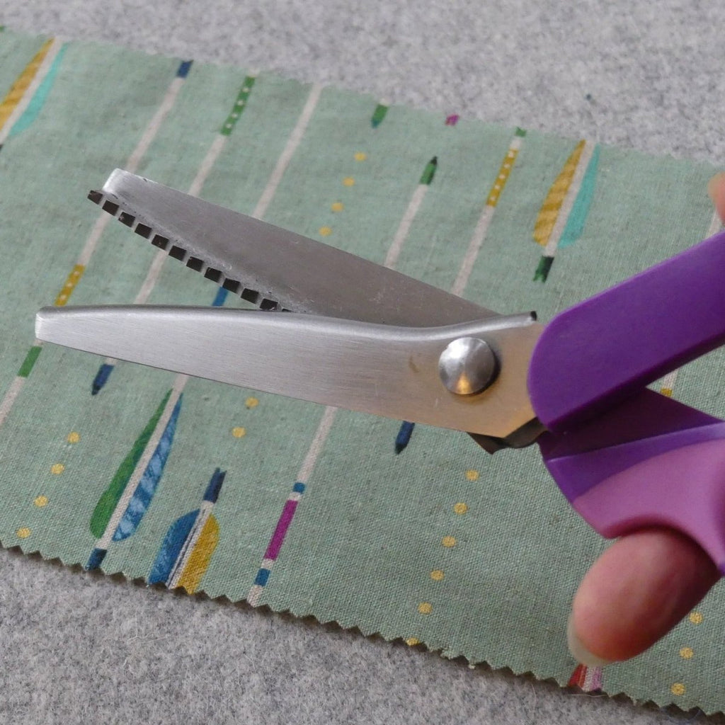 pinking shears with a zigzag edge held by a hand, 