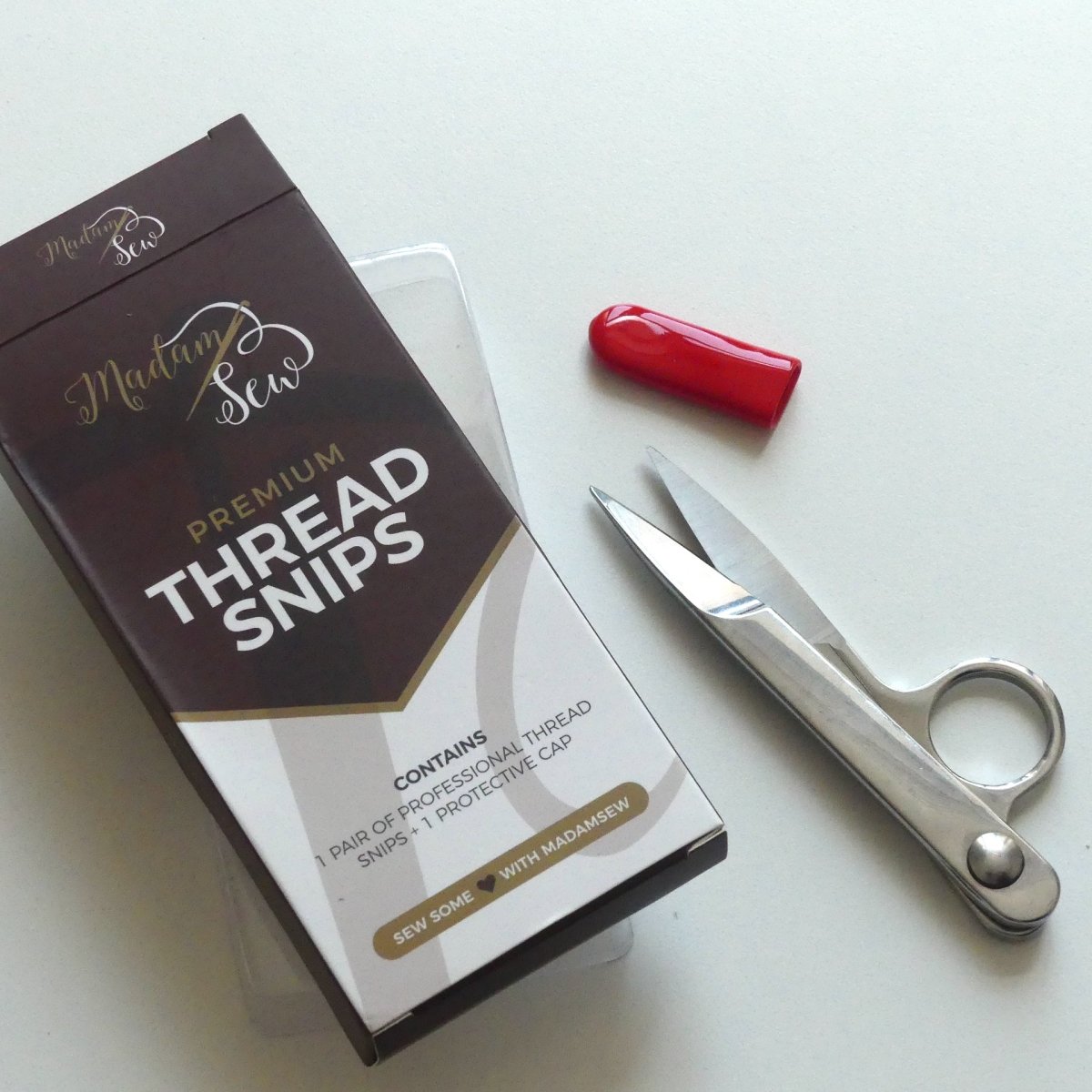 Thread snips with the red protection cap and the box