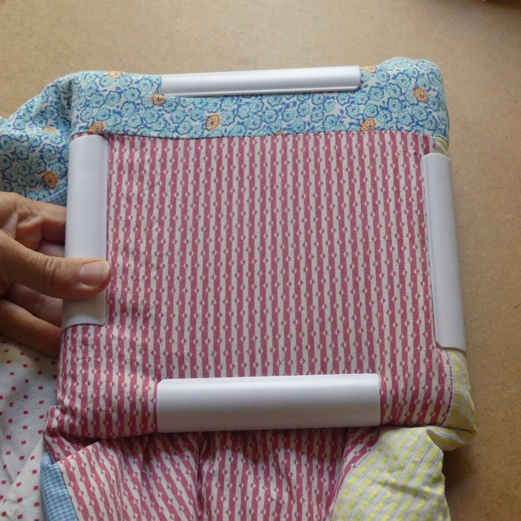 Colored fabric locked in place on the Quilt Frame.
