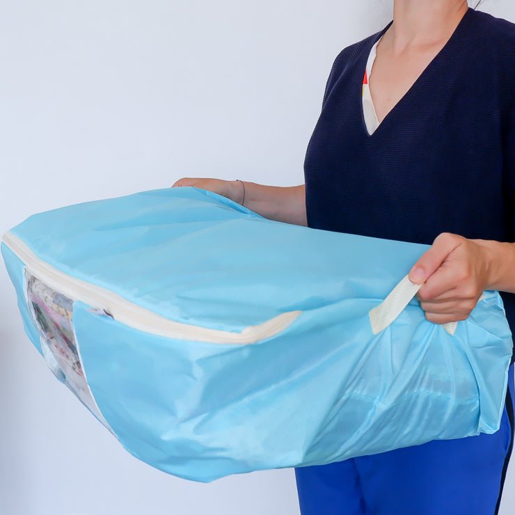 Women holding a quilt storage bag